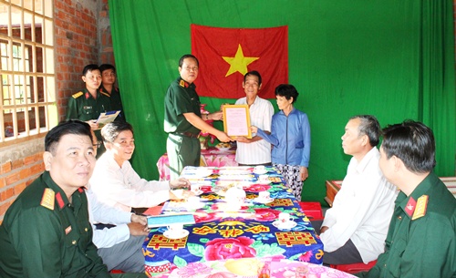 Đại tá Cao Văn Mĩa - Phó Chính ủy Bộ CHQS tỉnh trao quyết định quyền sử dụng nhà cho ông Phạm Văn Đấu